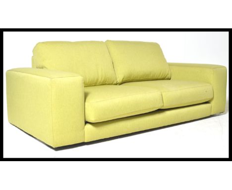 A contemporary Italian three seat sofa settee having three cushions to seat and backrest with squared armrest and upholstered