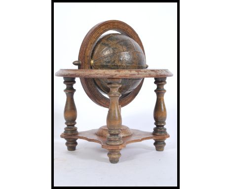 A vintage 20th Century desk globe antique style desk globe raised on a stained wood gimbal stand with turned legs. Measures 2