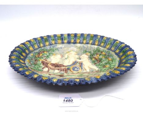 An antique manner of Palissy oval Dish moulded and painted in polychrome with a scene of he childhood of Bacchus, possibly 17