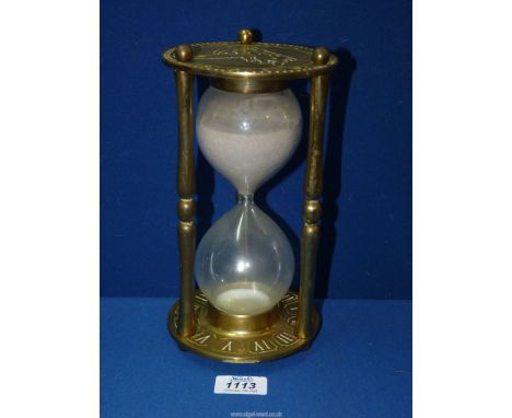 An Hour glass Brass sand Timer with Roman numerals and signs of the zodiac.