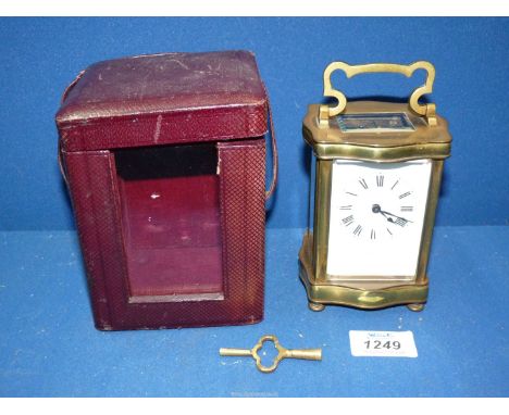 A serpentine shaped, brass framed and bevelled glass cased Carriage Clock the white enamelled face having Roman numerals and 