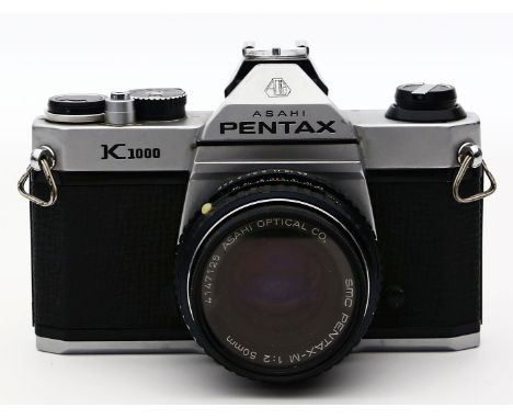 Kamera Pentax K1000. SLR mit SMC Pentax-M-Objektiv, 50 mm, 1:2. Kamera löst aus. Stärkere Gebrauchsspuren.