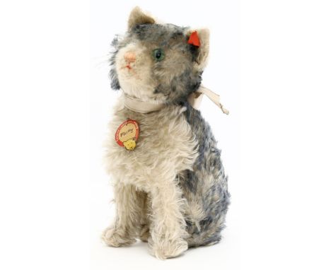 Steiff-Katze "Fluffy". Weißer und grauer Mohair, grüne Glasaugen. Halsmechanik, über Schwanz beweglicher Kopf. Mit K, roter F