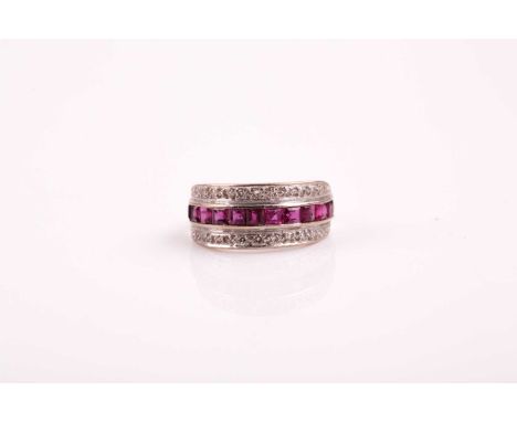 An Art Deco three row half hoop ruby and diamond eternity ring; the central band of calibre cut rubies flanked with rows of e