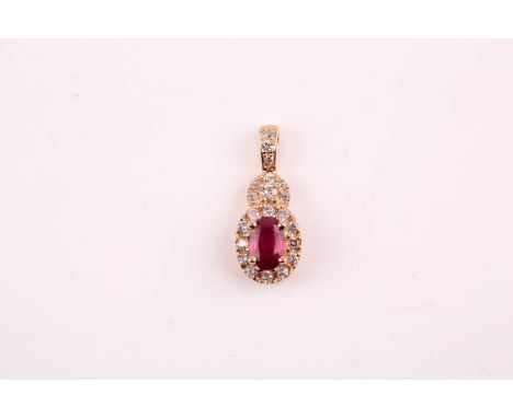 A 14k yellow gold, diamond, and ruby pendant, set with a mixed oval-cut ruby within a border of round brilliant-cut diamonds,