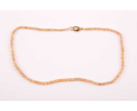 An opal beaded necklace, comprising of smooth beads displaying orange and green flashes of colour, with gilt metal clasp, nec