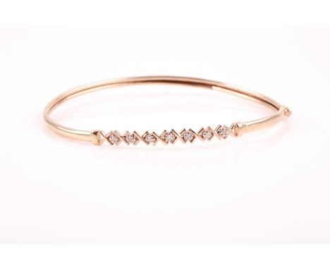 A yellow metal and diamond bangle, set with round-cut diamond accents, internal diameter approximately 6.5 cm, unmarked, 3.5 
