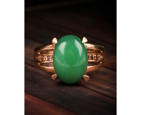 A jade and diamond ring, the oval jade cabochon, 14 x 10 mm, four claw mounts, to open-work diamond set shoulder and plain 9c