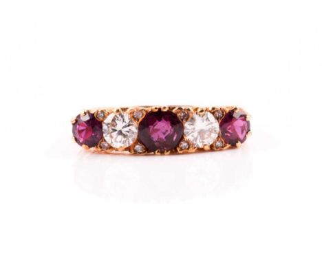 A five stone half hoop ruby and diamond ring; the round brilliant cut diamonds and circular cut rubies in carved claw mounts 