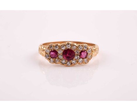 An 18ct yellow gold, diamond, and ruby ring, set with three round-cut rubies within a border of round brilliant-cut diamonds,