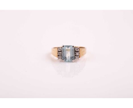 An aquamarine and diamond ring; the step cut aquamarine with three stone brilliant cut diamond borders to each side; to a pla