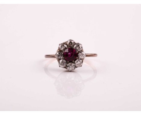 A French ruby and diamond cluster ring, the circular cut ruby claw mounted within a border of old brilliant cut diamonds to a