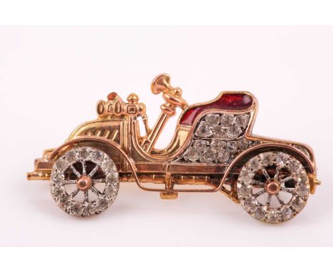 An unsual yellow metal and paste stone brooch in the form of a vintage car, with moving wheels, set with old-cut white paste 