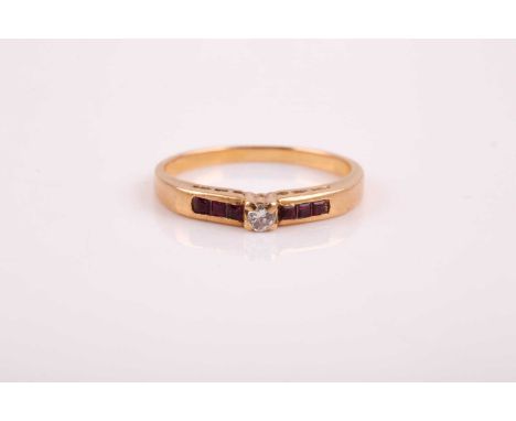 A yellow metal, diamond, and ruby ring, set with a round-cut diamond of approximately 0.06 carats, the shoulders channel-set 