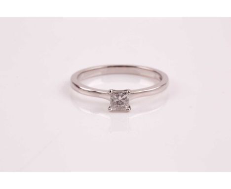 A single stone diamond ring, the princess cut diamond in simple four claw mount to a plain polished 18ct gold shank. Size R 4