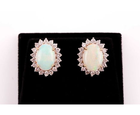 A pair of diamond and opal cluster earrings, set with oval cabochon opals within borders of round brilliant-cut diamonds, the