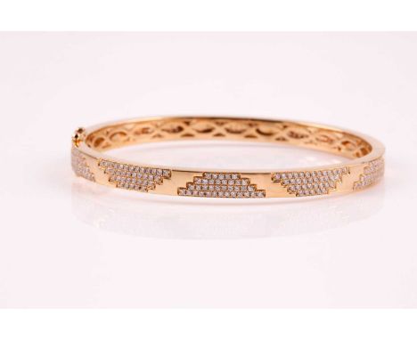 An 18ct yellow gold and diamond bracelet; the polished bangle with pave set round brilliant cut diamond panels; concealed cla