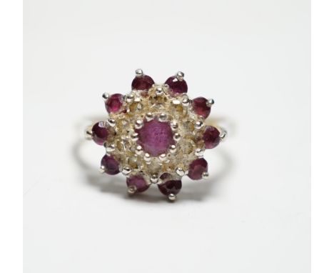 A modern 18ct gold, ruby and diamond set flowerhead cluster ring, size O, gross weight 5.2 grams.