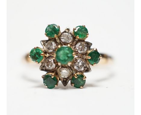 A 14ct, emerald and diamond set flowerhead cluster ring, size N/O, gross weight 3.2 grams.