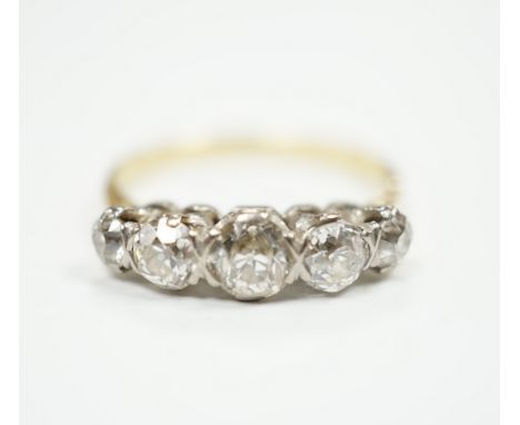 An antique yellow metal and graduated old round cut diamond set half hoop ring, size Q, gross weight 4 grams.