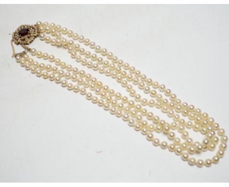 A 1960's triple strand cultured pearl necklace, by Cropp &amp; Farr, with 9ct gold, garnet and seed pearl set clasp, 40cm.
