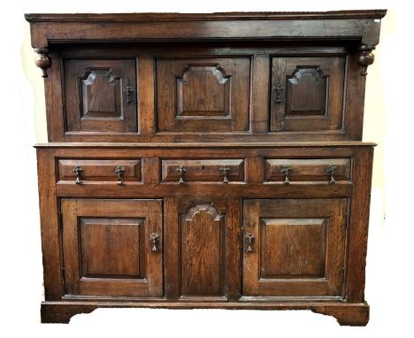 An 18th century joint oak court cupboard, with fielded panel doors flanking a dated center panel initialled and dated 'I I m 