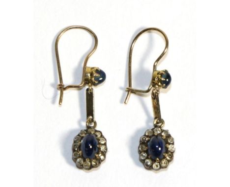 A Pair of Sapphire and Diamond Cluster Drop Earrings, an oval cabochon sapphire in a claw settings, suspends a sapphire caboc