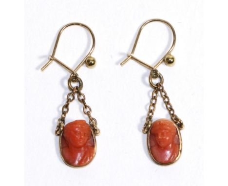 A Pair of Coral Cameo Earrings, each oval cameo carved in high relief with a classical female bust, suspended from chains to 