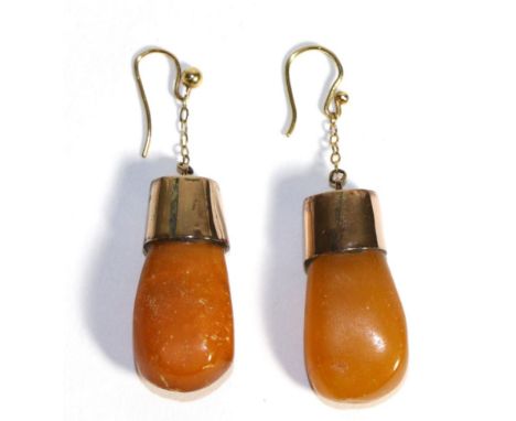A Pair of Amber Earrings, amber drops to rose coloured mounts, suspended from chains to hook fittings, length 5cmThere is lig