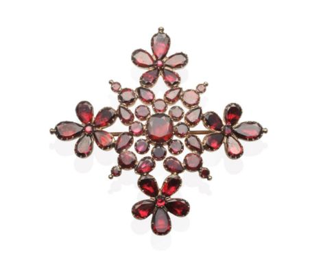 A Georgian Flat Cut Garnet Brooch, vari-cut garnets in closed back collet settings as a foliate motif cross, measures 6.5cm b