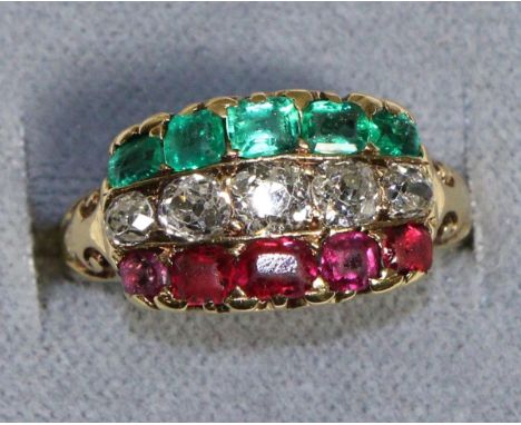 An Emerald, Diamond and Ruby Ring, as three gem set bands, to carved scroll shoulders, total estimated diamond weight 0.75 ca