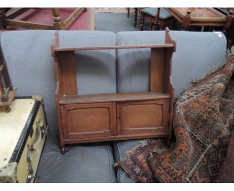 An Edwardian oak wall shelf having double cupboard