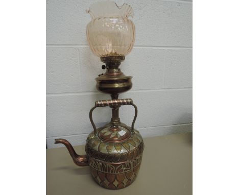 A vintage copper and brass oil lamp and an Indian style copper kettle with metal applique