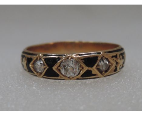 A late Victorian yellow metal and black enamel mourning band stamped 18ct having three graduated diamonds, approx .2ct and in