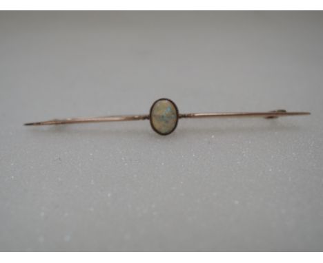 A yellow metal bar brooch stamped 9C having a central oval opal