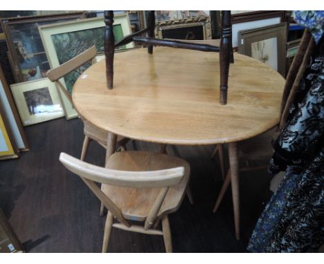 A 1970's Ercol light elm kitchen/dining suite comprising circular table and four solid seat chairs in the stacking style