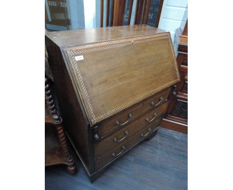 An Edwardian oak bureau having chevron line inlay decoration and drawer base on bracket feet