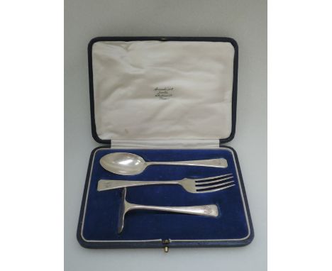 An infants cased silver three piece spoon, fork and pusher set of plain form, London 1925, Wakely & Wheeler