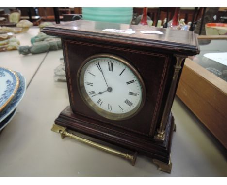 An Edwardian mahogany mantel clock having chequered line inlay and brass pillars