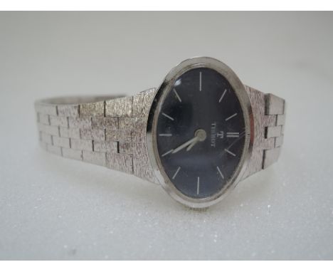 A silver plated wrist watch by Tissot having a baton numeral dial to oval blue face on a brushed brick effect strap