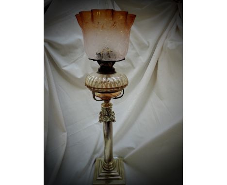 A 19th century brass oil lamp having corinthian style column, with foliate amber shade and fluted glass reservoir