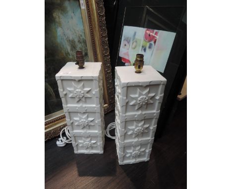 A pair of modern ceramic table lamps designed as white embossed towers