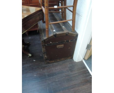A vintage wood bound dome top travel trunk