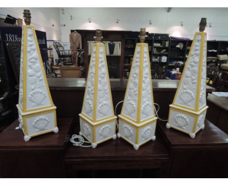 Four modern ceramic table lamps designed as white and yellow pyramids with shell decoration