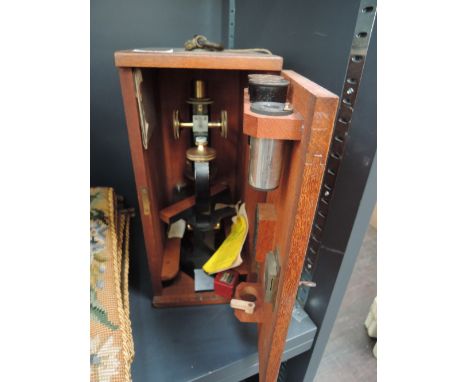 A mid 20th century microscope by R & J Beck, London, having lacquered brass finish with lenses and accessories in fitted maho