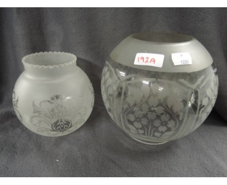 A thick glass period oil burner lamp with etched floral work and similar smaller shade
