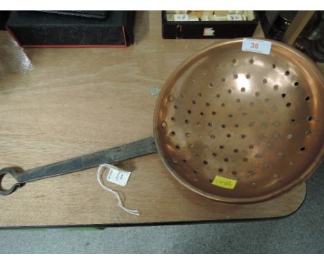 A vintage cast handle and copper bodied strainer of large form