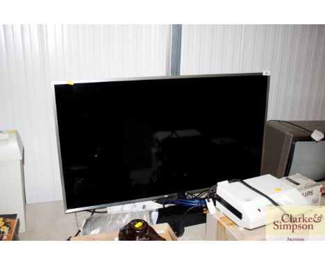 A Samsung flat screen smart TV with remote control and instruction manual, together with a Samsung sound bar with remote cont