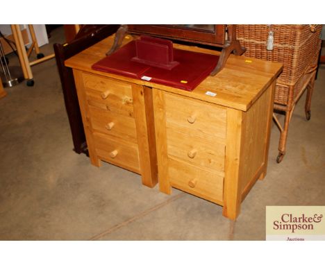 A pair of light oak bedside chests fitted three drawers
