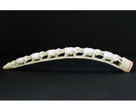 An African carved ivory tusk with a train of seven elephants. L43cm, approx. weight: 277g, early 20th century, with CITES Cer